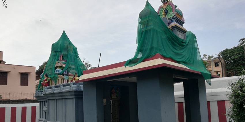 A picture of a Nagaraja temple in Kerala with blue exteriors and a covered Gopurama