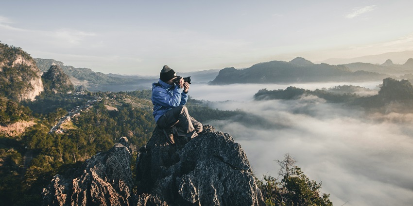 A person indulged in nature photography, capturing views with his professional camera.