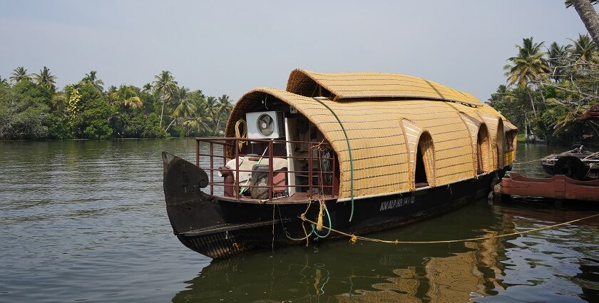 Houseboat on waters of Nedumudy, surrounded by lush greenery - water sports in Kerala