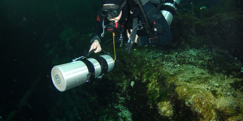 Sidemount diver pushing a cylinder in front