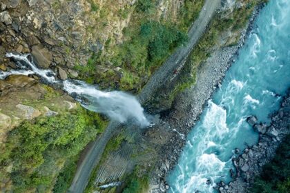 Aerial views of the thrilling waterfall coming down the hill through a vast forest in Idukki