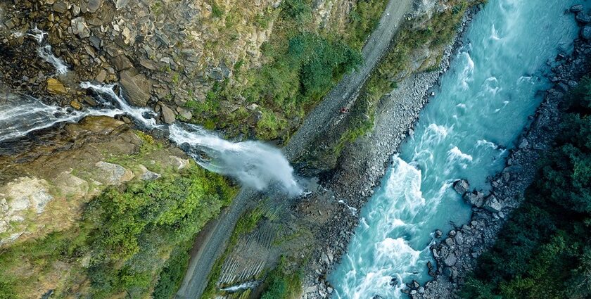 Aerial views of the thrilling waterfall coming down the hill through a vast forest in Idukki