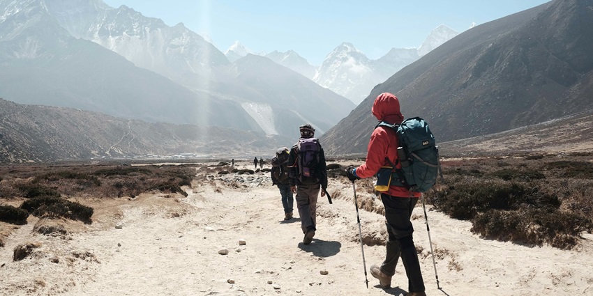 A glimpse of people trekking through the terrains near Madammakkulam Waterfalls.