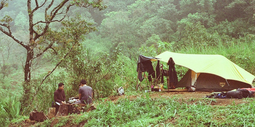 People camping and at a hilly terrain during day time
