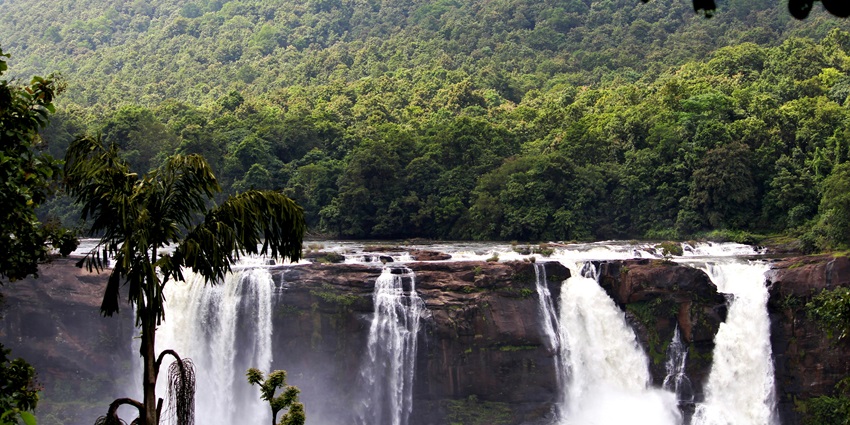 A breathtaking view of Palchuram Waterfalls surrounded by lush green vegetation.