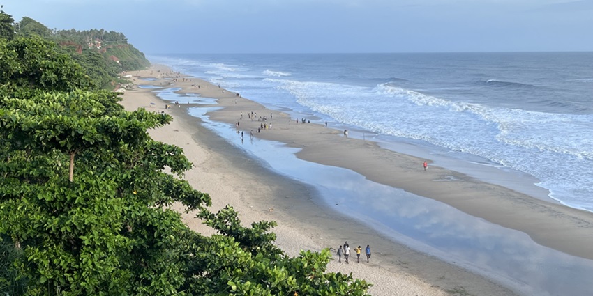 A panoramic view of people enjoying the scenic beauty and sea waves at Papanasam Beach
