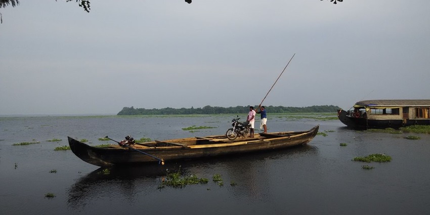 Pathiramanal Island surrounded by serene backwaters, with dense greenery and blue skies.
