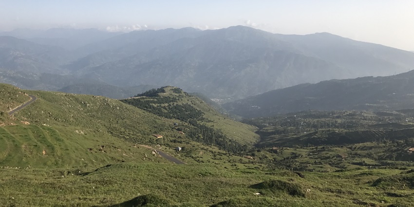 A breathtaking view of the lush green mountains of Jammu and Kashmir from a hilltop