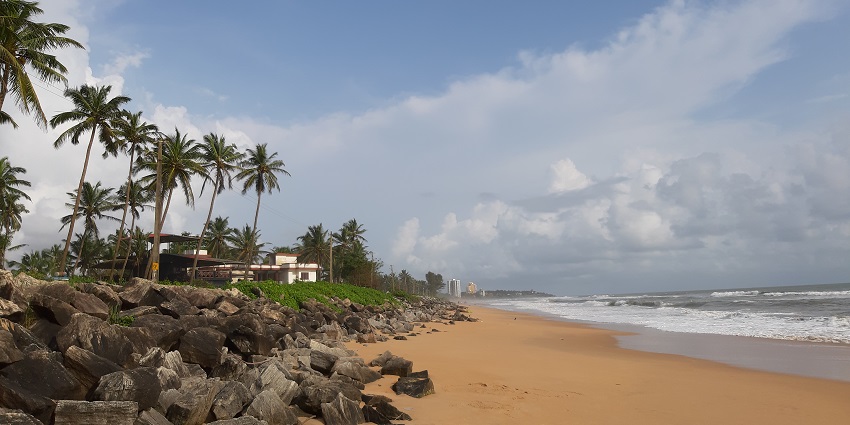 A breathtaking view of the Payyambalam beach with cloudy skies in the background