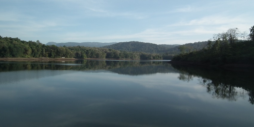Peechi Dam area with its vast reservoir, surrounded by greenery and distant hills.