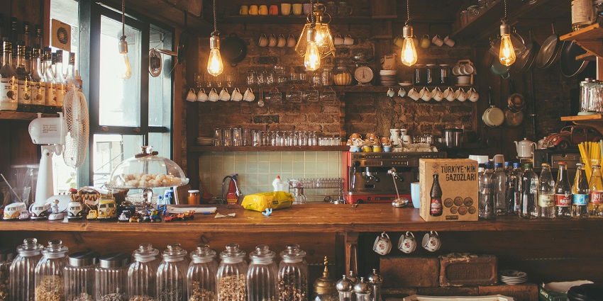 The front counter of a bar with lights and glasses in the background