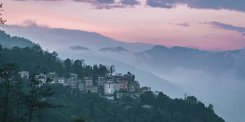 High-rise buildings against a backdrop of mountains - places to visit in north east India