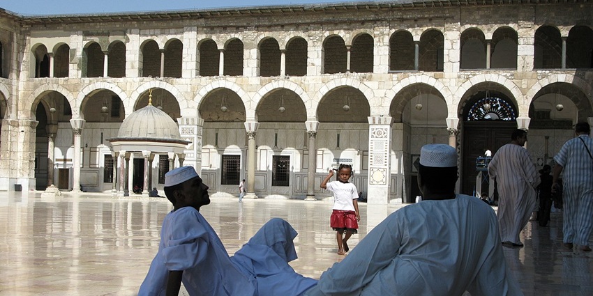The worshippers of the mosque sit and engage with each other through culture and religion.