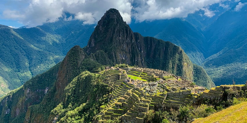 A mesmerising view of lush greenery on a mountain peak with cloudy skies in Peru