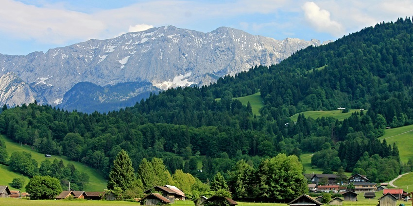 Traveler capturing breathtaking views of mountains and valleys with a DSLR.