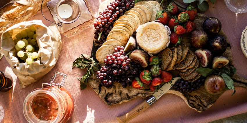 Image of cookies, fruits, and juice served on a picnic sheet - things to do at the waterfalls