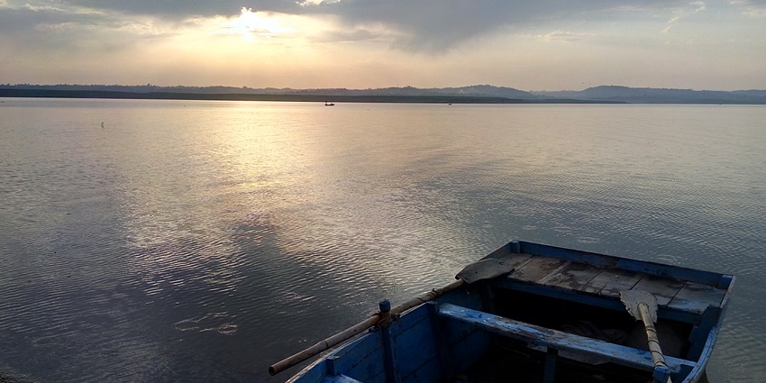 Evening view of a tranquil Pong Dam lake with surrounding hills and calm waters.