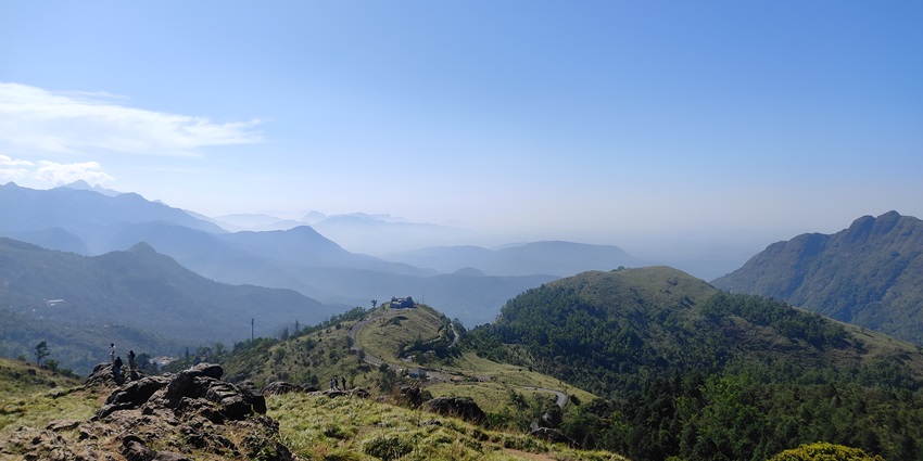 A scenic view of the hills and valleys in Kerala’s Ponmudi region under the cover of mist