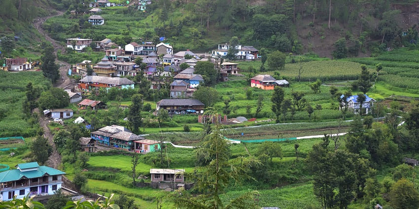 Traditional wooden houses nestled among green fields and trees similar to Rakchham