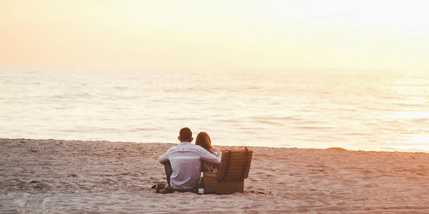 A couple enjoys some quiet moments on a beach while experiencing the beauty all around