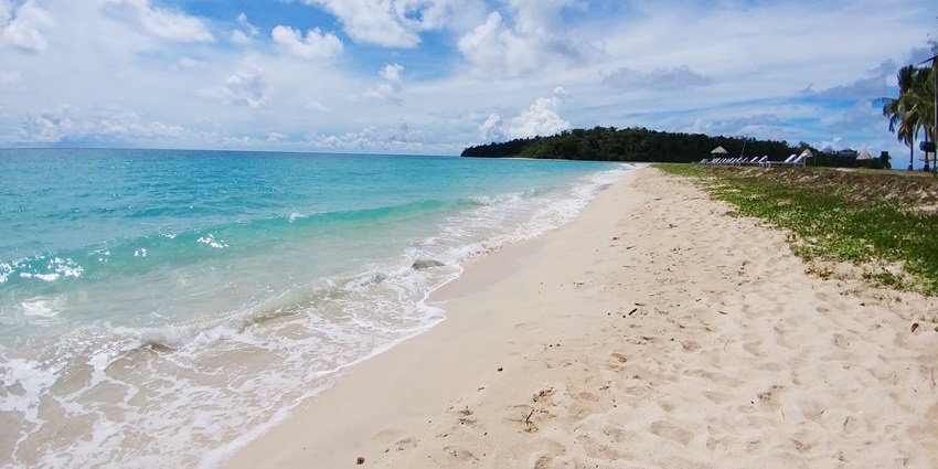 Twin islands connected by a white sandbar surrounded by turquoise blue waters.