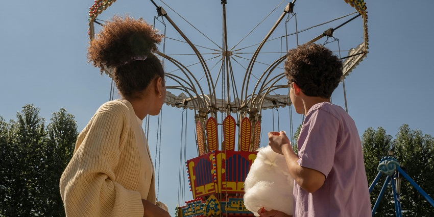 Teenage kids in amusement park looking at big carousel - best theme parks in Kerala