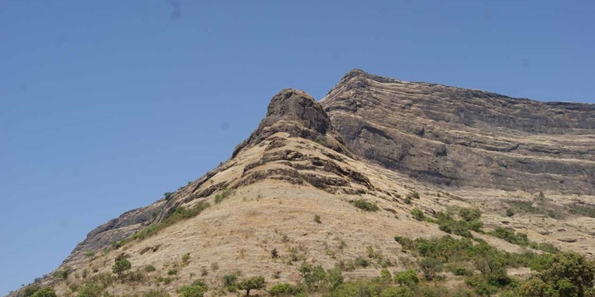 A picture of the ruins of a historical fort situated on top of a grassy mountain