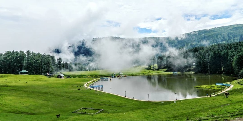View of Sanasar Lake surrounded by green landscape, dense forests, and a cloudy backdrop