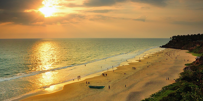 Golden sun rays shimmer over a serene beach as gentle waves kiss the sandy shore.