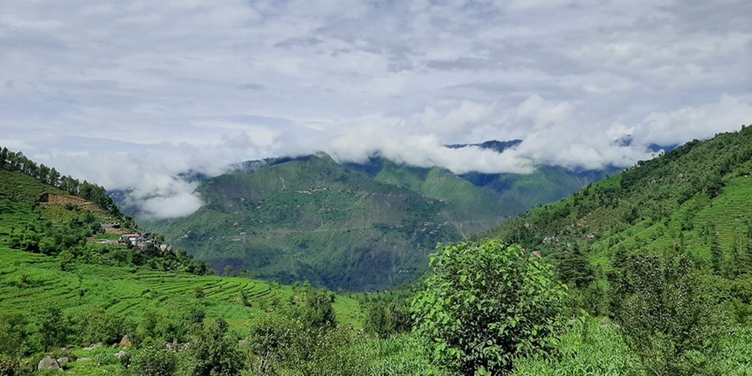 A panoramic view of a charming hill town that is laden with greenery and lofty hills