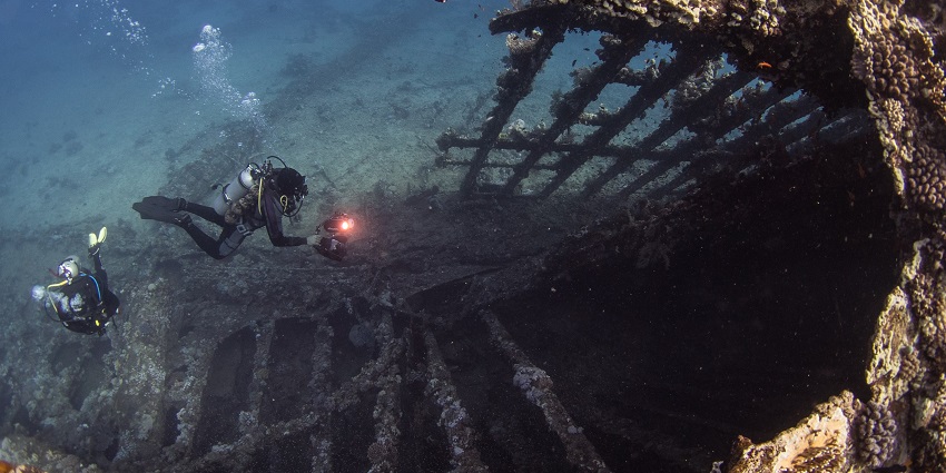 Scuba divers are exploring a giant underwater cave on their adventure