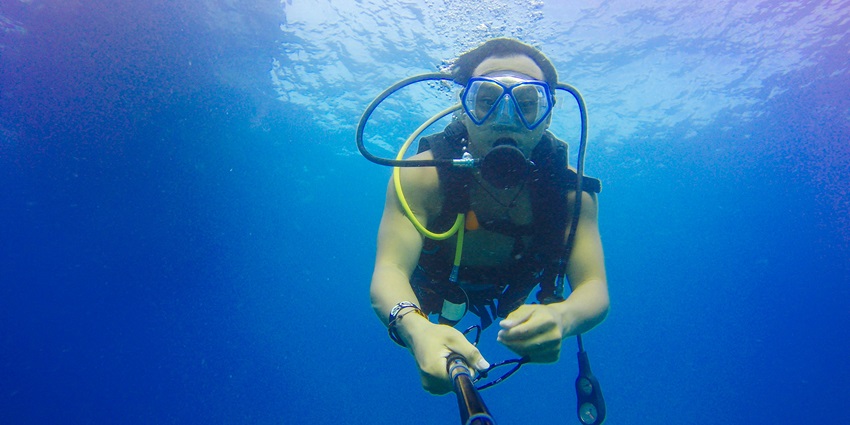 A mesmerising view of a man clicking pictures of himself while scuba diving underwater.