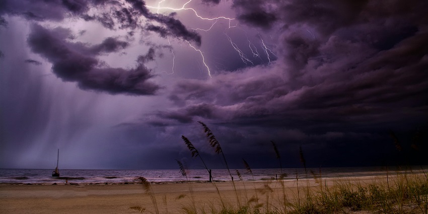 The view of a beach during rain and a thunderstorm that can affect scuba diving