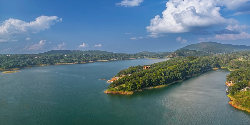 The view of serene Umiam Lake in Shillong, surrounded by lush hills and greenery.