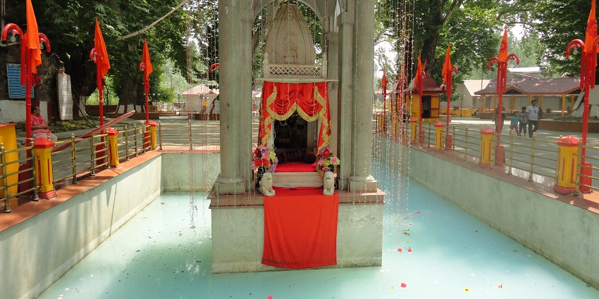 The view of serene Shree Kheer Bhawani Durga Temple surrounded by lush greenery.