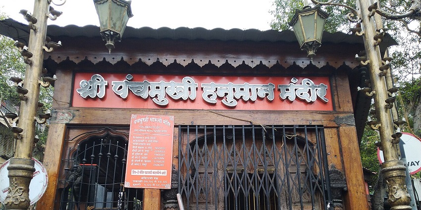 A frontal view of a Hanuman Temple in Srinagar with two street lamps in front