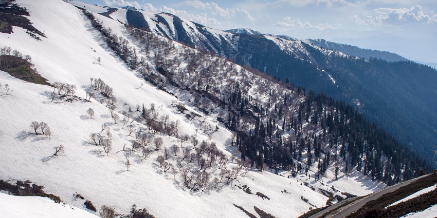 Scenic mountain road winding through snowy terrain at Sinthan Top in Kashmir