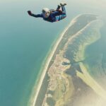 A person indulging in a thrilling adventure of skydiving, one of the top activities.