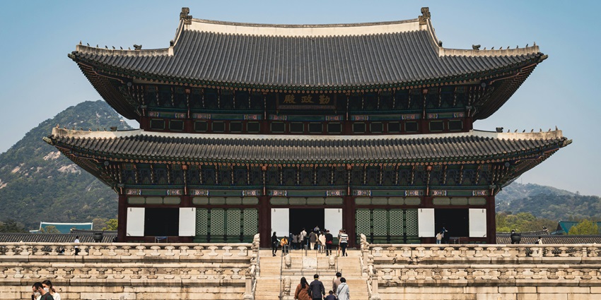 View of people visiting a temple in Seoul to seek blessings & explore the architecture