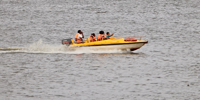 A picture of a family that is indulged in speed boating amidst the splashes of waves.