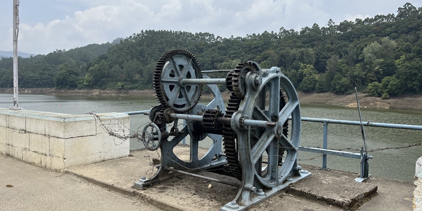 A picture of the Kundala Arch Dam with machinery in front and the lake in the background