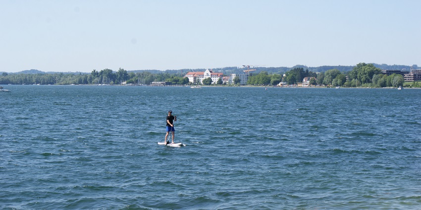 Man in the ocean performing Stand up Paddleboarding - Water sports in Varkala, Kerala