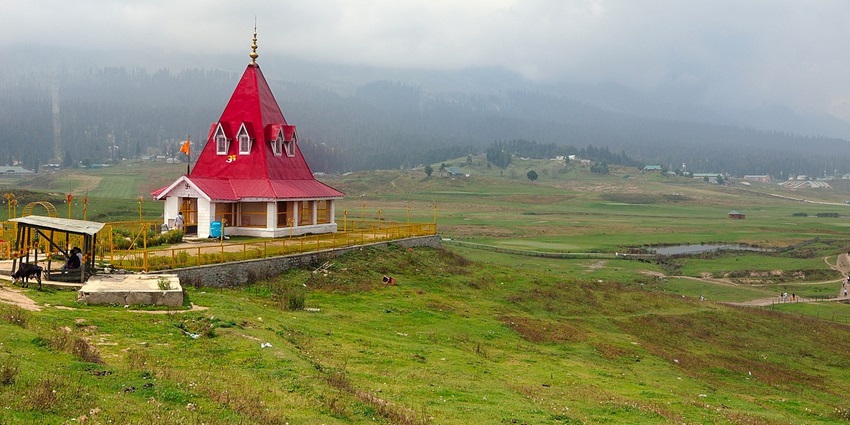 Ancient Maharani Temple in Gulmarg framed by mountainous backdrop and lush greenery