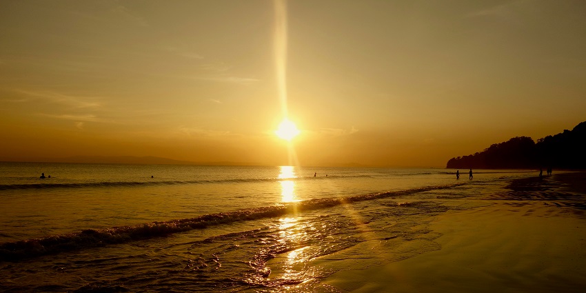 Sun setting and painting the sky with red hues, a scenic dusk at Radhanagar Beach.