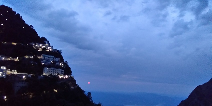 A mesmerising sunrise view amidst mountains and cloudy blue skies at Vaishno Devi