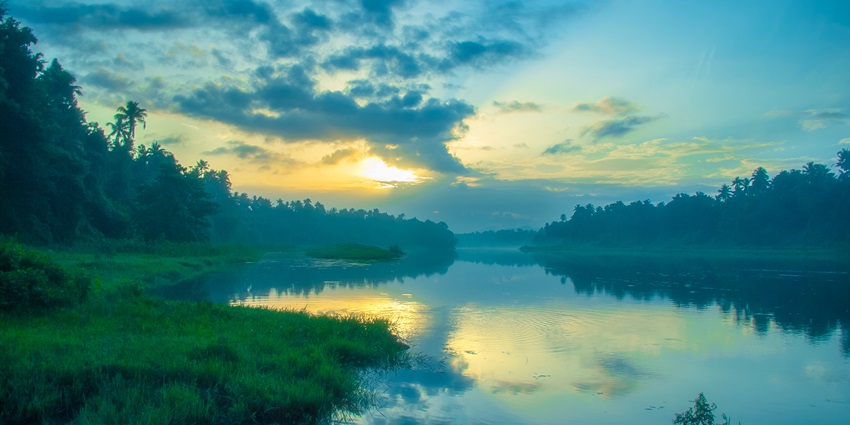 A serene view of sunrise captured at the banks of the Chalakudy River near Athirapally
