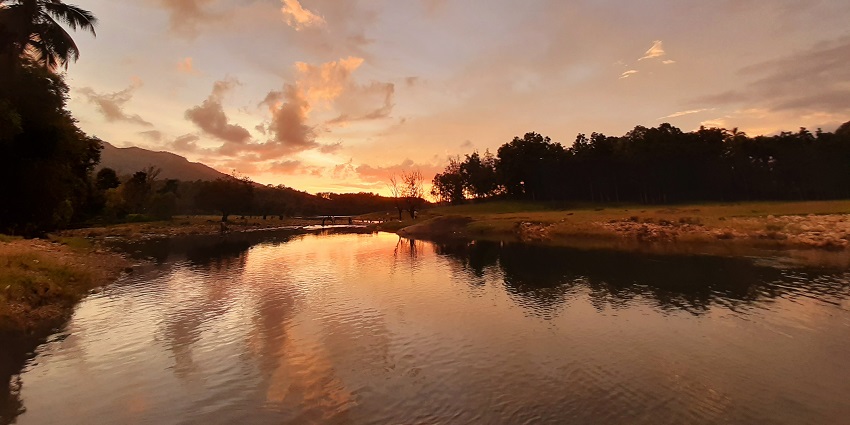 Sunset at Kakkayam Dam, casting vibrant hues over tranquil waters and green surroundings