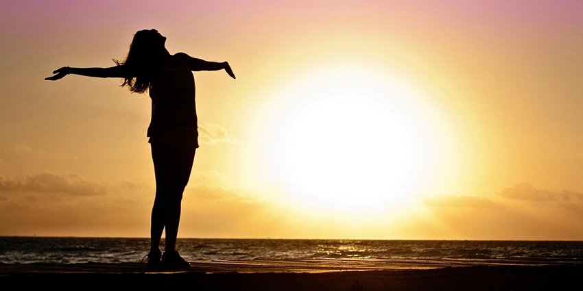 Woman traveller enjoying beach sunset - view of the sunset and sunrise at the beach