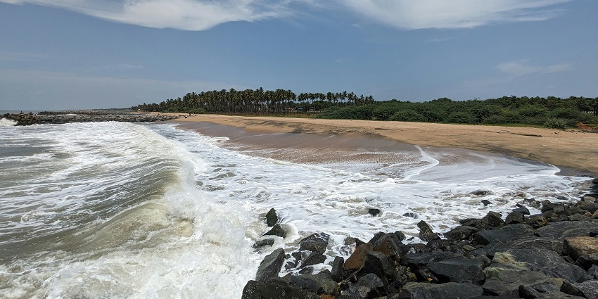 Quiet coastal stretch with gentle waves, ideal for swimming, sunbathing, and peaceful seaside relaxation.