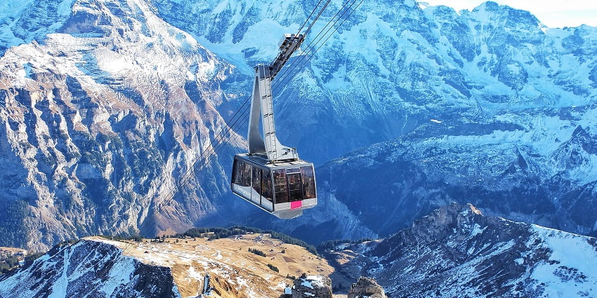 Bird's eye view of the ski lift over the scow-clad mountains during winter in Switzerland